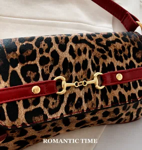 Détail du sac léopard avec garniture en cuir rouge et boucle mors en métal doré