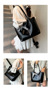 Detail of black large capacity tote bag with white lace bow and pearl charm ornament