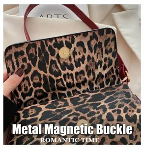 Détail du fermoir magnétique doré sur sac léopard avec bandoulière en cuir rouge