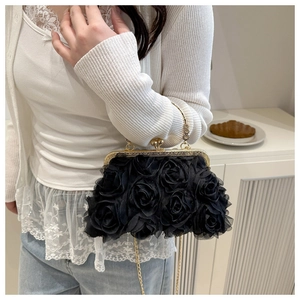 Detail of elegant black evening bag featuring 3D rose petals and golden ball clasp hardware