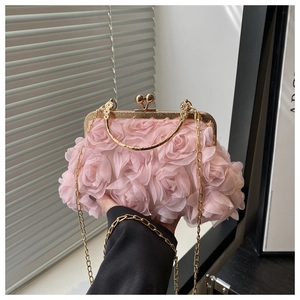 Detail of pink 3D fabric rose petals on evening clutch with gold metal handle