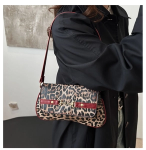 Détail du sac à main léopard avec garniture en cuir rouge et boucle mors dorée