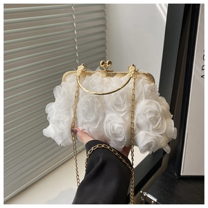 Detailed close-up of white 3D floral evening bag with golden chain and clasp