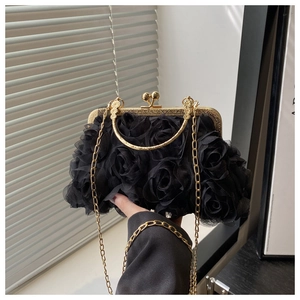 Detailed view of black 3D mesh roses on evening bag with golden metal frame and chain