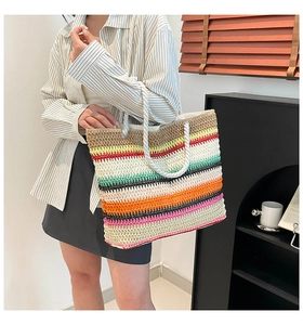 Gros plan du sac cabas en paille à rayures arc-en-ciel avec poignées en corde de coton