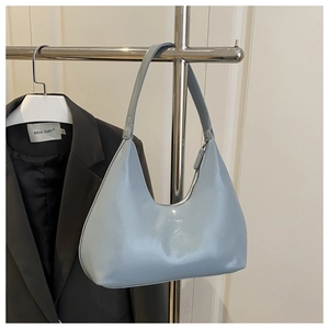 Close-up of light blue hobo bag with glossy leather and metal display stand detail