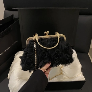 Elegant black evening bag featuring 3D floral petals and a gold chain strap