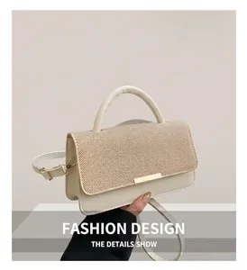 Détail du sac bandoulière crème avec rabat en texture tissée et boucle en métal doré