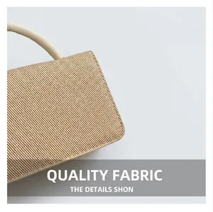 Gros plan sur la texture tissée beige et la poignée crème d'un sac à main minimaliste