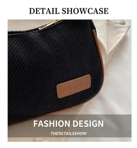 Close-up of black woven fabric texture with brown leather logo patch and gold zipper