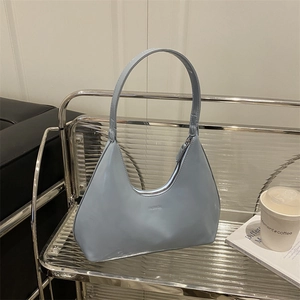 Minimalist light blue hobo bag with FASHION text on industrial stainless steel shelf