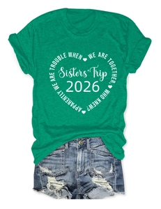 Détail du t-shirt vert pastel avec motif Sisters' Trip 2026 et short en jean effiloché