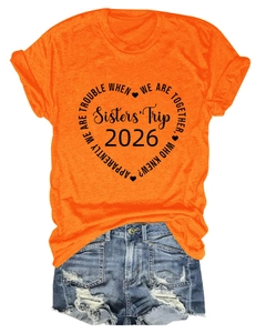 Mise à plat du t-shirt orange Sisters Trip 2026 avec un short en jean déchiré