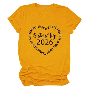 Gros plan du motif cœur Sisters' Trip 2026 sur un t-shirt jaune vif en coton