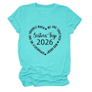 Détail du tissu en coton turquoise et de l'imprimé coeur Sisters' Trip 2026 sur le t-shirt