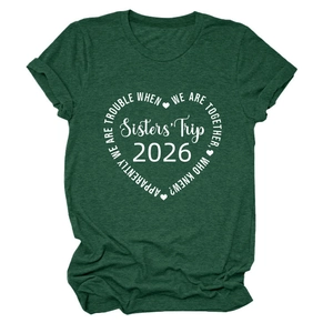 Détail de l'imprimé Sisters' Trip 2026 sur un t-shirt vert foncé à manches courtes et col rond