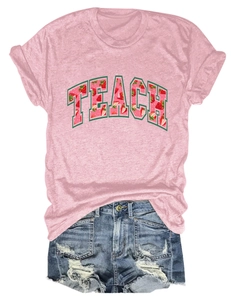 Flat lay of pink cotton T-shirt featuring strawberry TEACH print and denim shorts