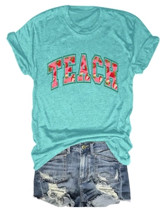 Close-up of TEACH slogan with strawberry pattern print on a turquoise crew neck t-shirt