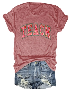 Flat lay detail of brick red TEACH strawberry tee paired with ripped denim shorts