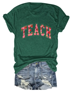 Flat lay of a dark green t-shirt with TEACH strawberry print and denim shorts