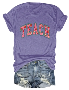 Flat lay of purple cotton T-shirt featuring strawberry TEACH print and denim shorts