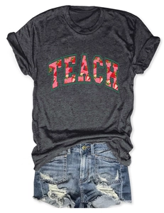 Close-up of TEACH letter print with realistic strawberry pattern on heather gray cotton T-shirt