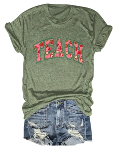 Detail of olive green t-shirt with TEACH strawberry print and distressed denim shorts