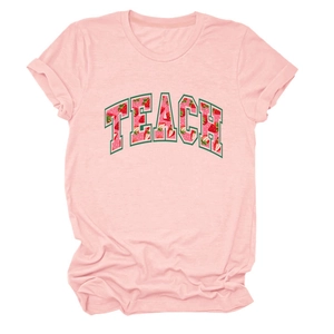 Close-up of pink cotton T-shirt featuring TEACH text with red strawberry pattern fill