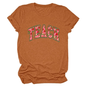 Close-up of TEACH lettering with strawberry pattern on orange crewneck t-shirt