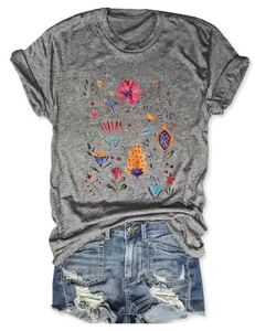 Detail of grey floral t-shirt with folk print and distressed denim shorts with ripped holes
