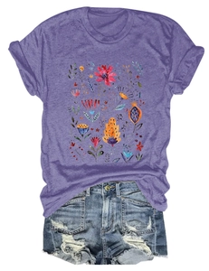 Detailed flat lay of a purple T-shirt with watercolor floral print and ripped denim shorts