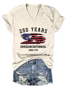 Flat lay of off-white V-neck tee with US flag print and distressed denim shorts set