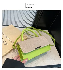 Détail du sac bandoulière en similicuir vert avec rabat tressé beige et fermoir doré