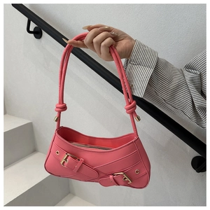 Détail du sac sous l'aisselle rose avec boucles de ceinture et poignée à nœuds à la main