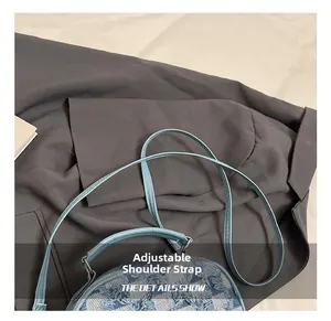 Λεπτομέρεια του ρυθμιζόμενου ιμάντα denim σε μια μοντέρνα τσάντα ώμου με αστέρια
