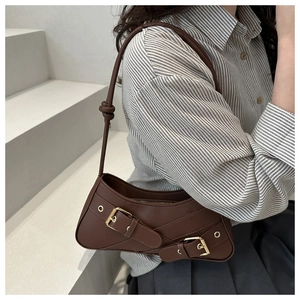Fashionable dark brown underarm bag with gold metal buckles and cylindrical strap detail