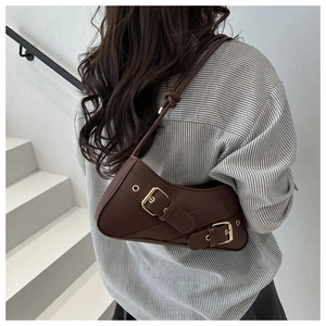 Détail d'un sac sous le bras Y2K marron avec de grandes boucles dorées et des œillets