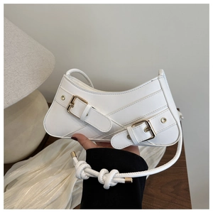 Détail du sac sous l'aisselle en cuir ciré blanc avec boucles de ceinture et bandoulière nouée