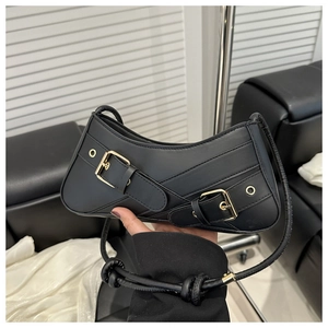 Détail du sac hobo noir avec boucles vintage, œillets métalliques et bandoulière nouée