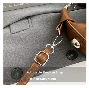 Detail of adjustable leather shoulder strap with silver metal swivel hook and buckle