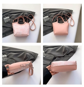 Detail view of pink silk handbag with floral embroidery and adjustable strap