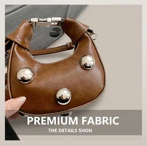Detailed macro view of the brown mini crescent bag featuring silver rivet decorations