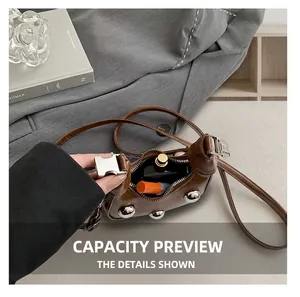 Close-up of brown studded mini shoulder bag interior showing capacity and zip opening