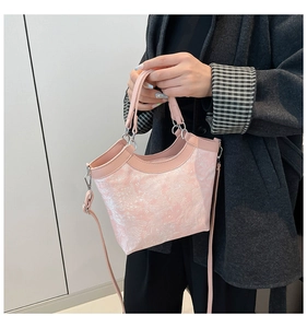 Detailed view of pink silk floral embroidery on a chic Chinese-style bucket handbag