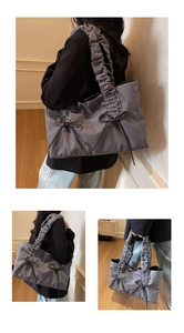 Détail du sac cabas en nylon gris-mauve avec volants plissés et nœuds en ruban noir