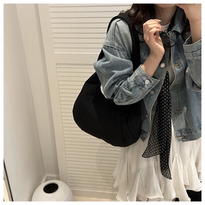 Vue lifestyle d'un sac demi-lune en nylon noir porté en bandoulière par un mannequin