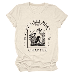 Detailed view of Just One More Chapter gothic skeleton reading graphic on beige t-shirt