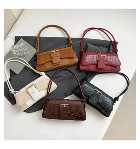Flat lay of crocodile pattern baguette bags in yellow, burgundy, white, brown, and black