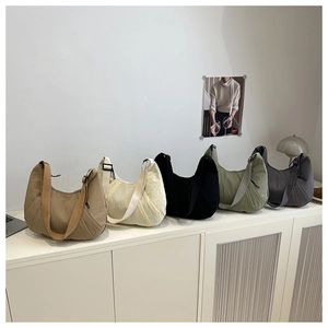 Série de sacs bandoulière demi-lune en cinq couleurs montrant les détails du tissu