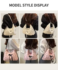 Detailed views of quilted polka dot hobo bag with bow details and silver heart pendant